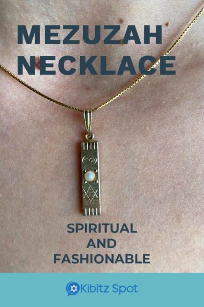 A gold mezuzah necklace being worn