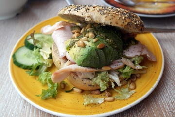 Turkey with avocado and pine nuts sandwich made on a bagel