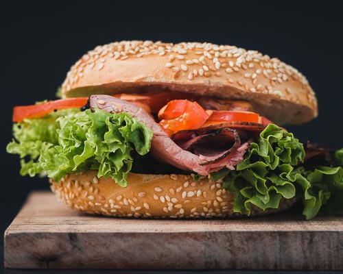 Pastrami sandwich on a bagel with lettuce and tomato