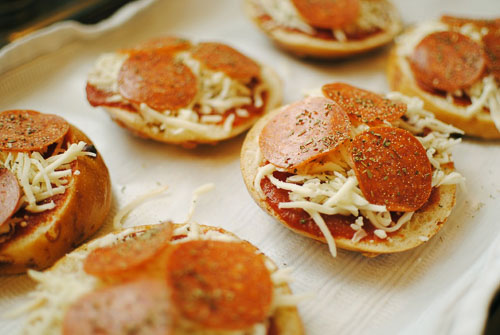 Pizza bagel topped with sauce, cheese, and salami 