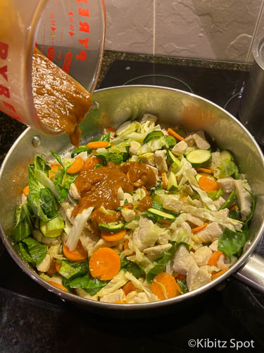 Pouring sauce into the pan on top of the meat and vegetables