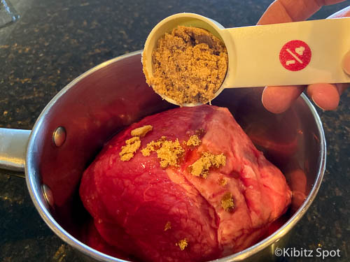 Pouring brown sugar over the brisket