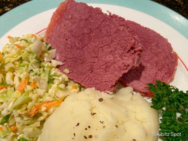 Our homemade Jewish corned beef on a plate with cole slaw and mashed potatoes