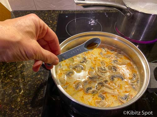 Adding fish sauce to our nearly completed tom kha gai soup recipe