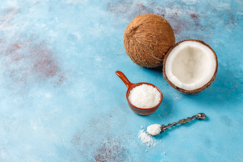 an open coconut and a measure of shredded coconut for the best coconut pie recipe