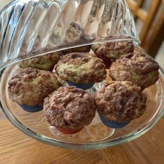 Cinnamon Zuccini Muffins on a glass cake plate with lid