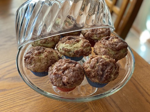 Cinnamon Zuccini Muffins on a glass cake plate with lid