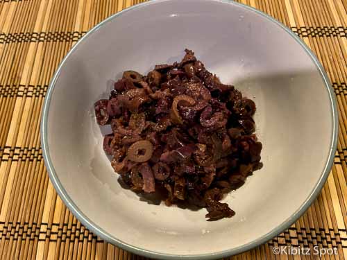 Sliced kalamata olives amongst the baked baked potato vegan toppings