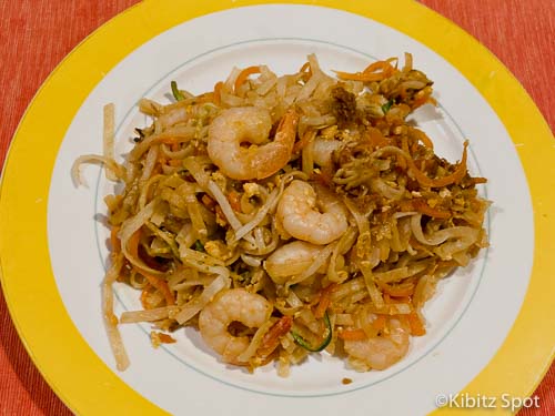 A plate of healthy pad thai featuring shrimp, vegetables, and rice noodles. 