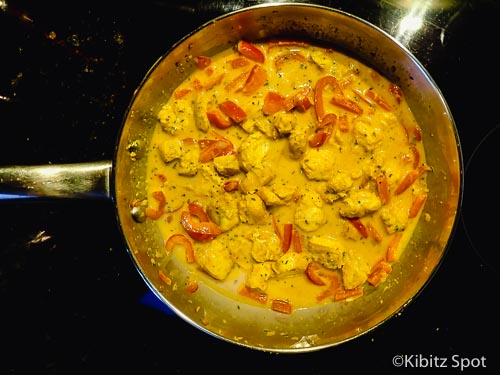 Malaysian fish curry in the pan with coconut milk added