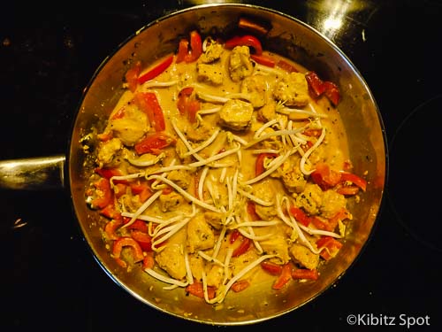 Coconut fish curry in a pan with bean sprouts added