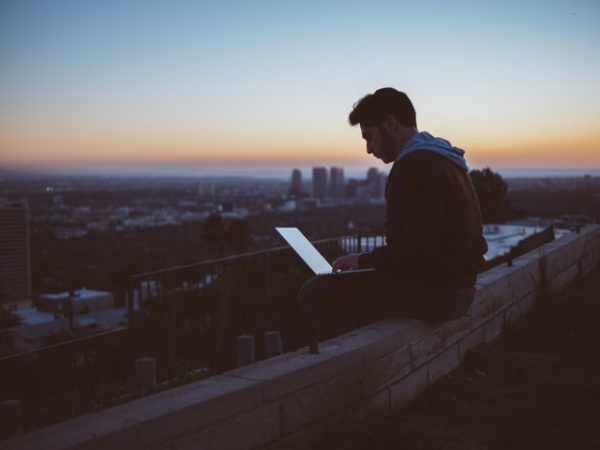 man sitting on rooftop with computer learning modern Hebrew