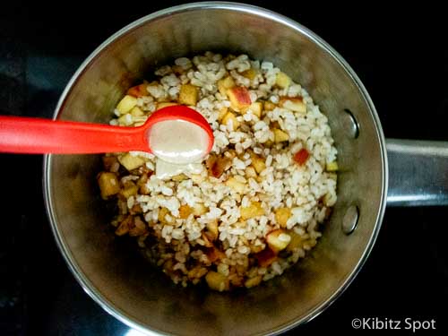 Adding tahini to the saucepan of our apple cinnamon rice porridge breakfast