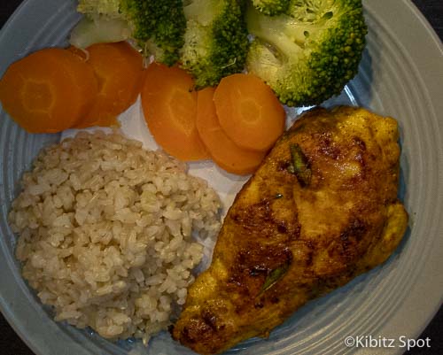 A plate Vietnamese Grilled Chicken served with rice, cooked carrots, and broccoli .