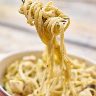 A plate of garlic spaghetti with a fork loaded with a bite of it