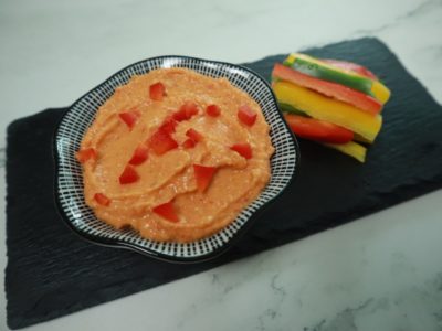 red pepper hummus recipe prepared with veggie sticks for dipping