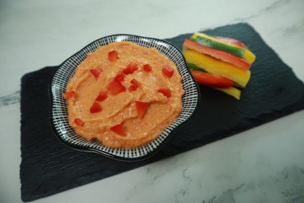 red pepper hummus recipe prepared with veggie sticks for dipping