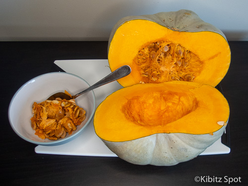 Scooping out the squash seeds with a spoon.