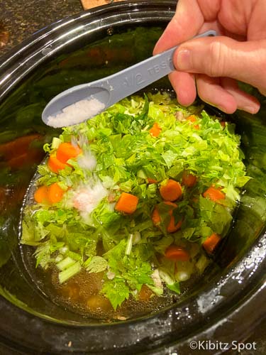 Adding salt to a pot of chicken soup