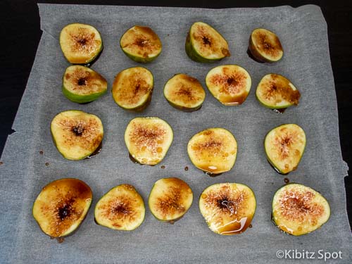 tray of figs cut in half, with balsamic vinegar and honey, ready to be roasted.