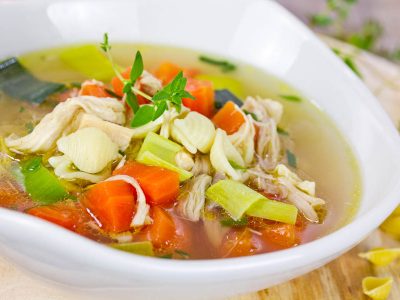 Gluten Free Chicken Soup - a big bowl of clear broth with roughly chopped carrots, celery, and chicken