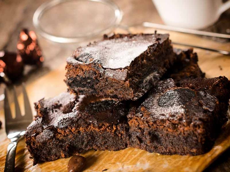Three homemade brownies on a plate, made from the ultimate gooey chocolate brownie recipe