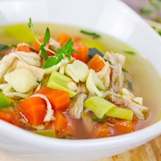 Gluten Free Chicken Soup - a big bowl of clear broth with roughly chopped carrots, celery, and chicken