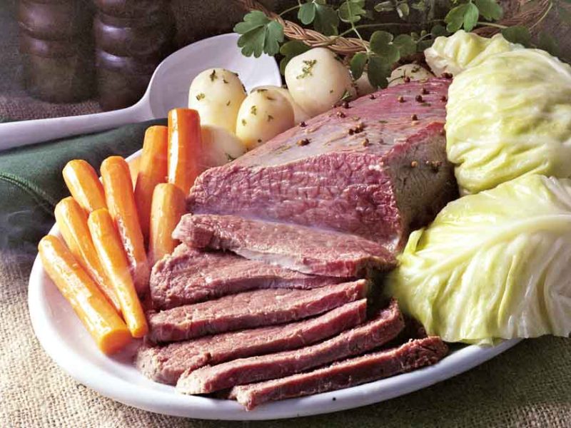 A plate of our homemade simple corned beef recipe, plated with carrots, potatoes, and cabbage.