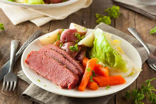 A plate of our simple corned beef recipe, with carrot, cabbage, and potatoes drizzled in gravy