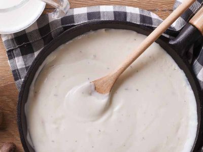 gluten free bechamel sauce in a pan and milk on the table.