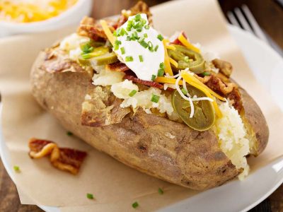 An example of some baked potato bar ideas - this potato is loaded with jalapeños, cheese, chicken-bacon, and sour cream