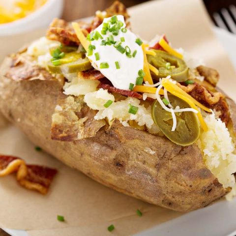 An example of some baked potato bar ideas - this potato is loaded with jalapeños, cheese, chicken-bacon, and sour cream