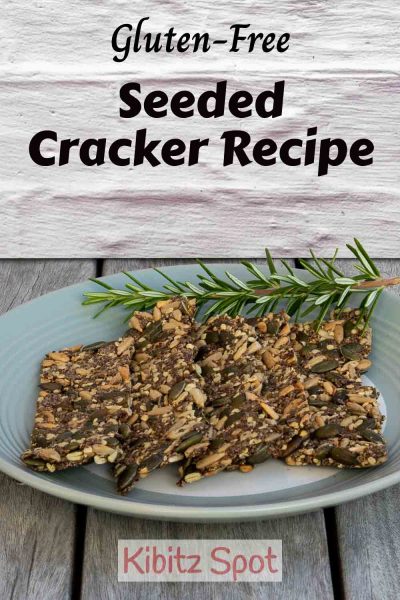 A plate of gluten free seeded crackers and a sprig of rosemary