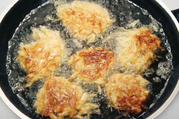 A pan of gluten-free latkes being fried in oil