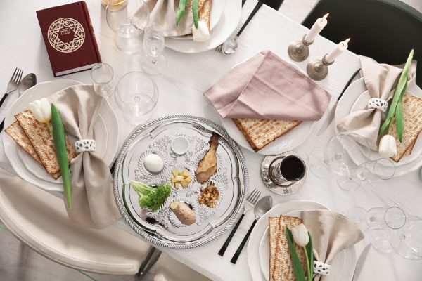 Festive Passover table setting with Torah, a modern seder plate, top view. Pesach celebration