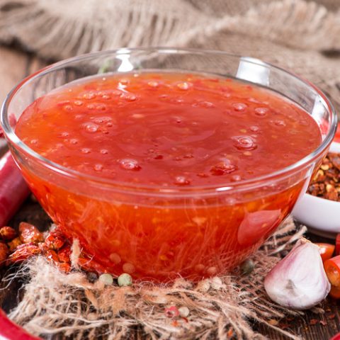 Closeup of Sweet chili ginger sauce with some of the ingredients used to make it