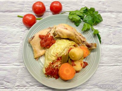 Our delicious chicken and cabbage recipe made in a crockpot and now ready to eat on a plate with tomato
