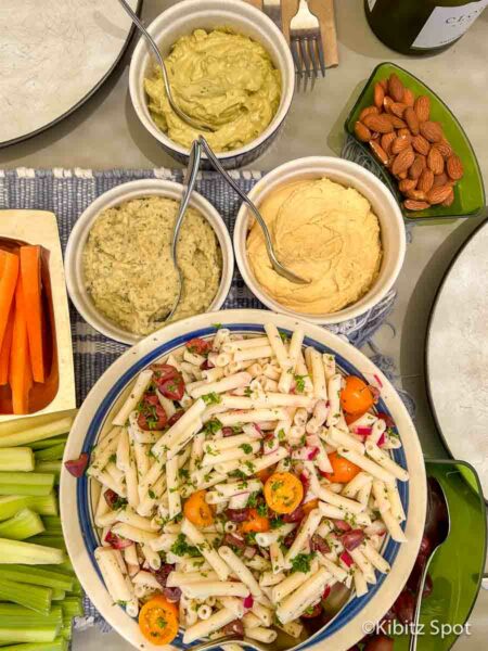 Our vegan gluten-free pasta salad along side three dips and fresh veggies on a mezze platter