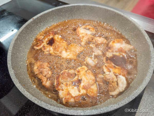 Chicken cooking in a pan with teriyaki sauce