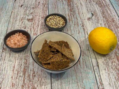 Crunchy quinoa crackers in a bowl with some of the ingredients used to make them