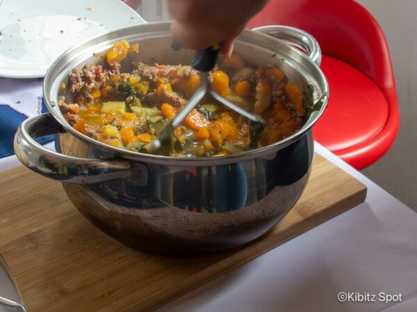 Mashing the cooked charquican ingredients