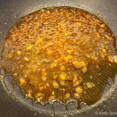 Gluten-free stir-fry sauce being thickened in a wok