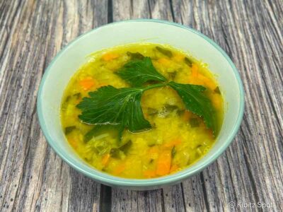 A bowl of carrot and lentil soup using red lentils ( masoor dal ), garnished with a celery leaf