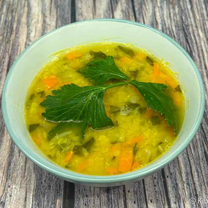 A bowl of carrot and lentil soup using red lentils ( masoor dal ), garnished with a celery leaf